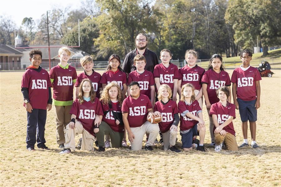 The flag football team pose for a group picture. 